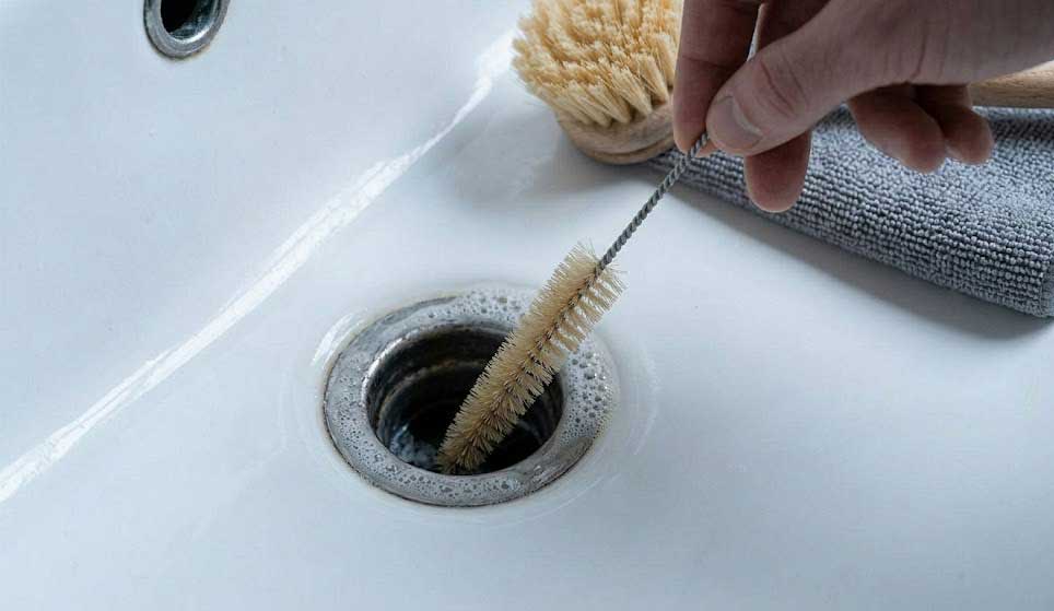 Καθαρισμός νιπτήρα με βούρτσα.